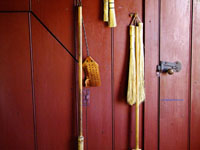 corn brooms on red wall